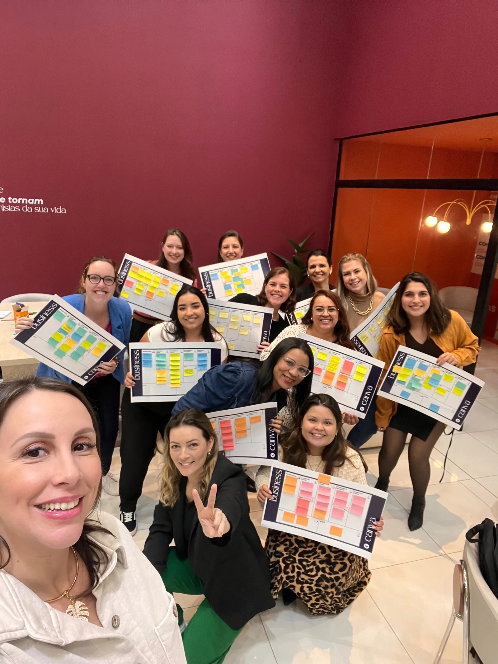Mulheres segurando cartazes com post-its em um encontro da Valens